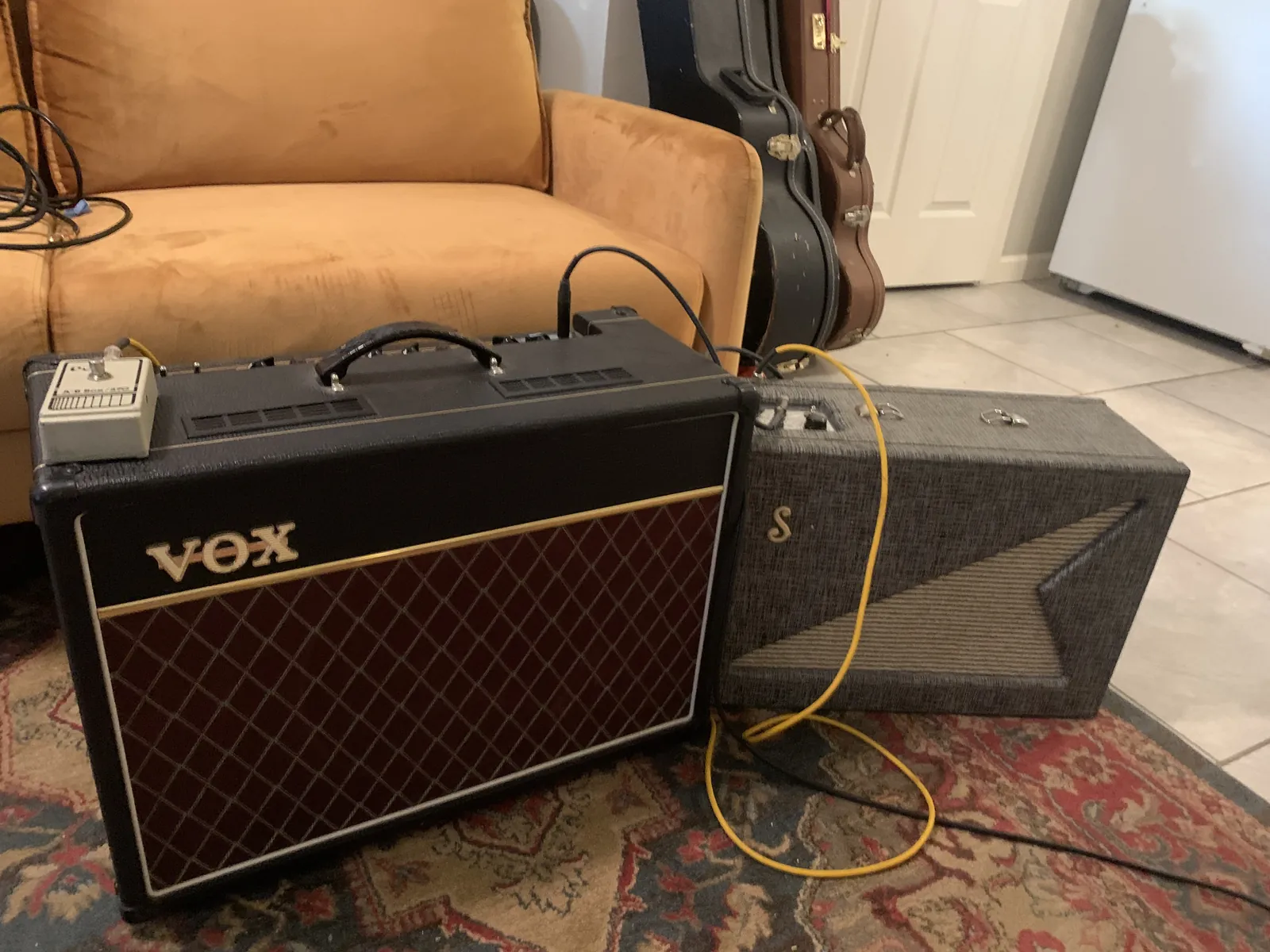 Supro reverb unit next to a Vox combo amplifier on a rug
