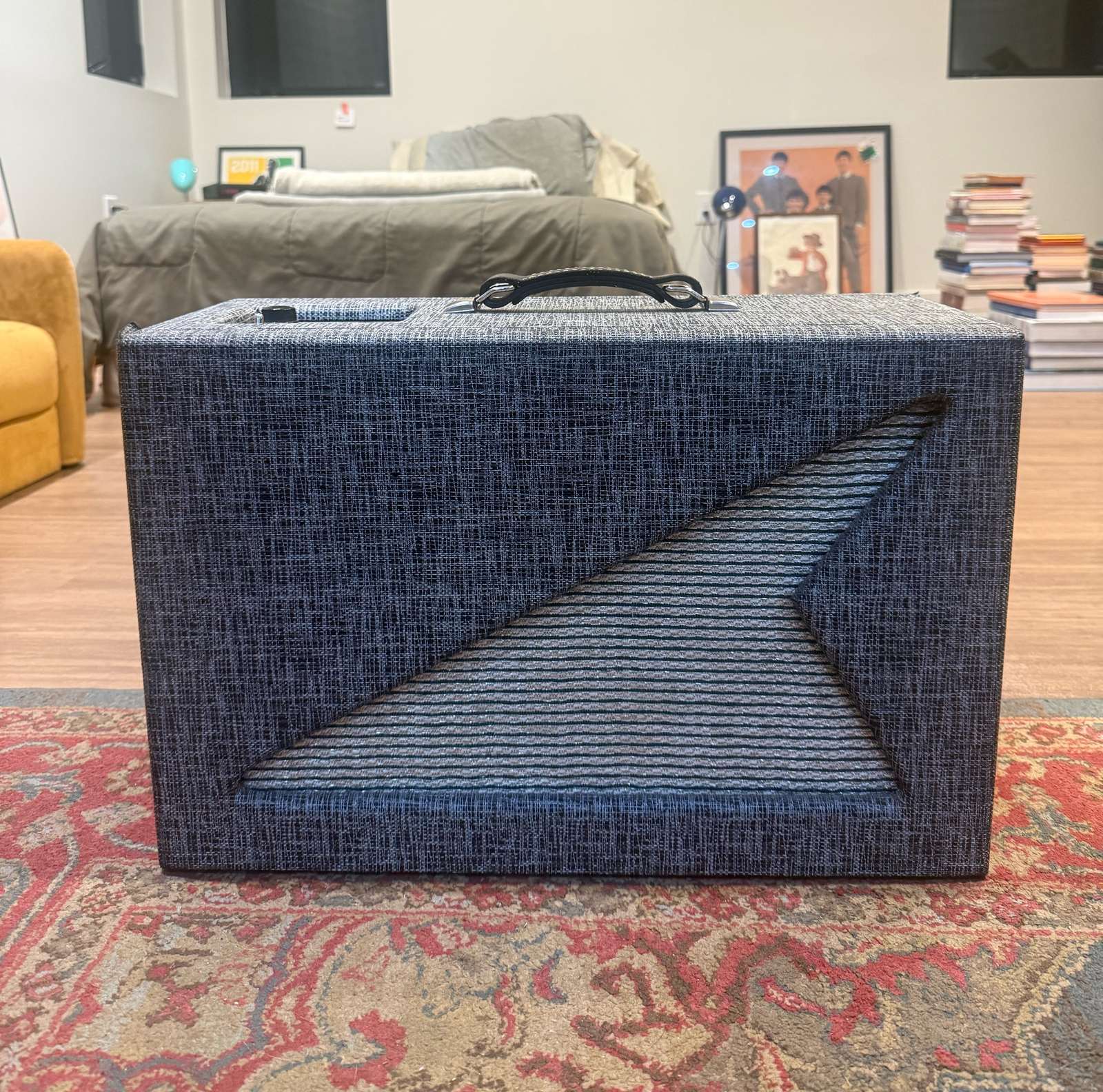 Finished Supro 600R Reverberation Unit cabinet in slate-blue tweed with the diagonal cutout grille, sitting on a red rug